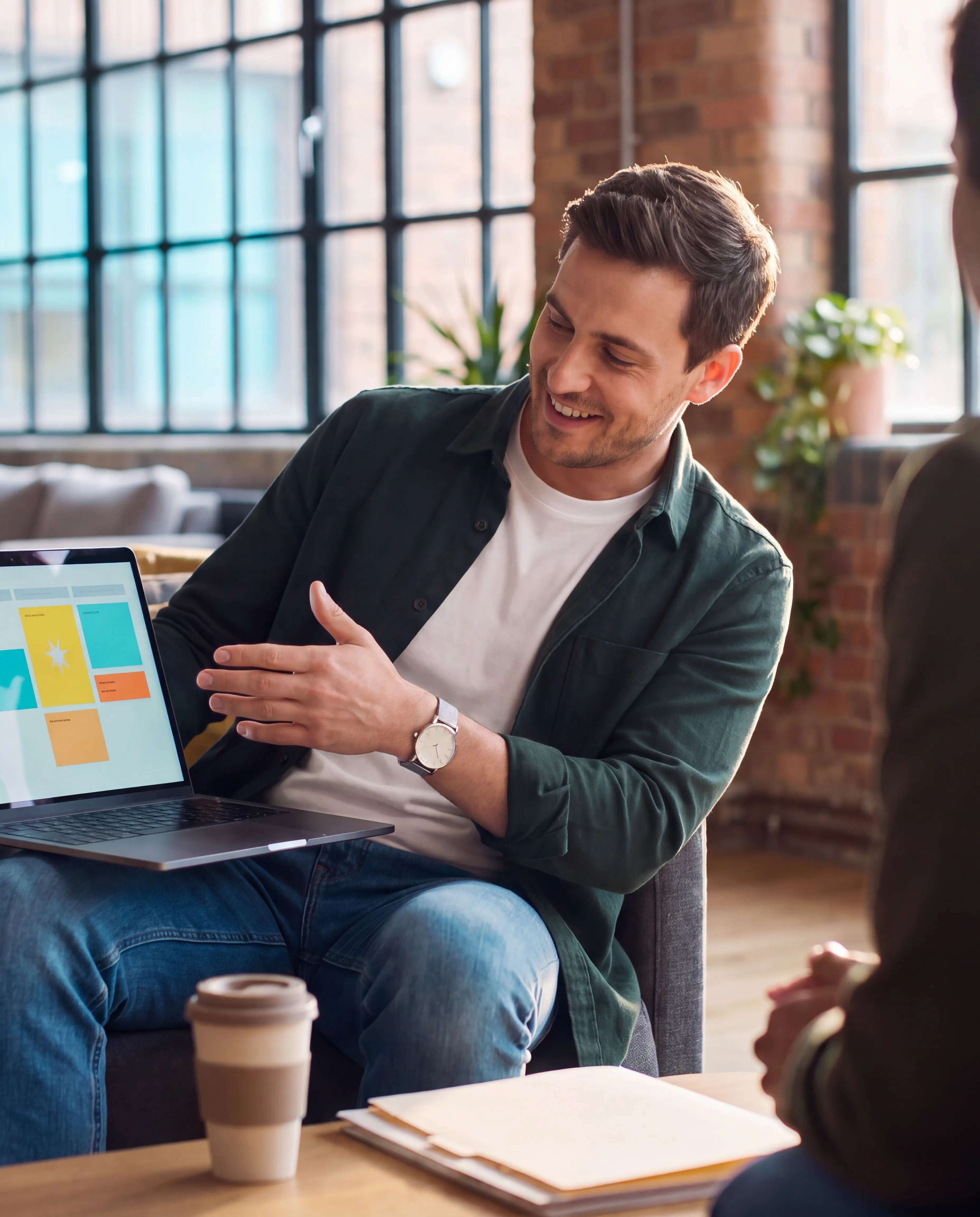 Consultant explaining a dashboard on a laptop during a workspace meeting